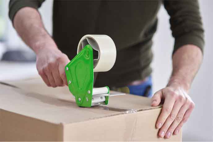 man taping up a upack moving box